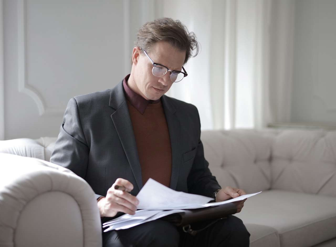 busy man in suit checking through documents 