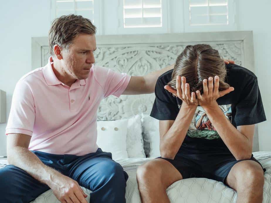 A young man who just experienced breakup being comforted by his dad